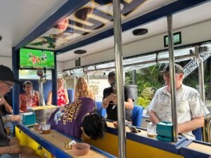 Guests and a purple-shirted team member gathered around the bar inside Damasta Booze Cruiser.