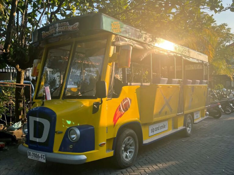 Warm sunlight shining through trees onto the front and side of the yellow Damasta Booze Cruiser.